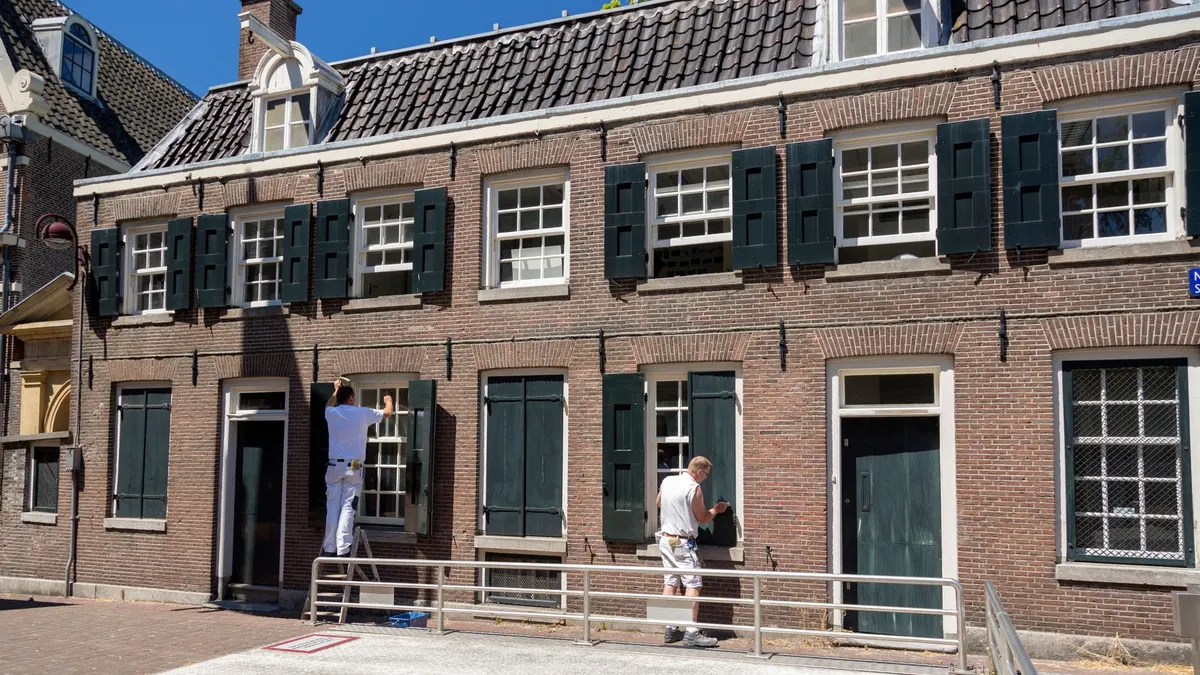 House exterior being painted on a clear, sunny day