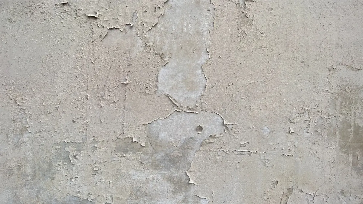 Wall with wallpaper texture being assessed before painting
