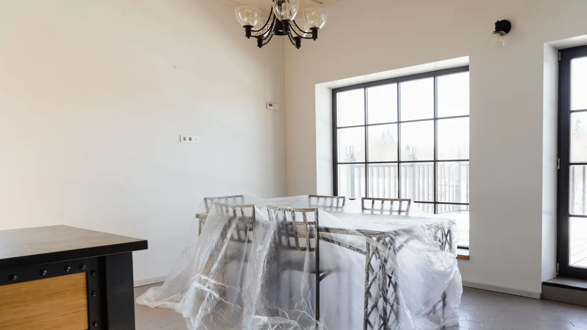 Living room furniture covered with plastic sheeting before painting