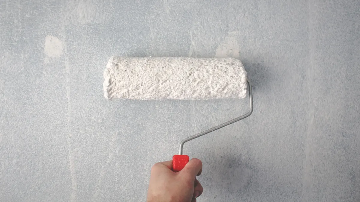 Can of primer with a roller resting on top before painting