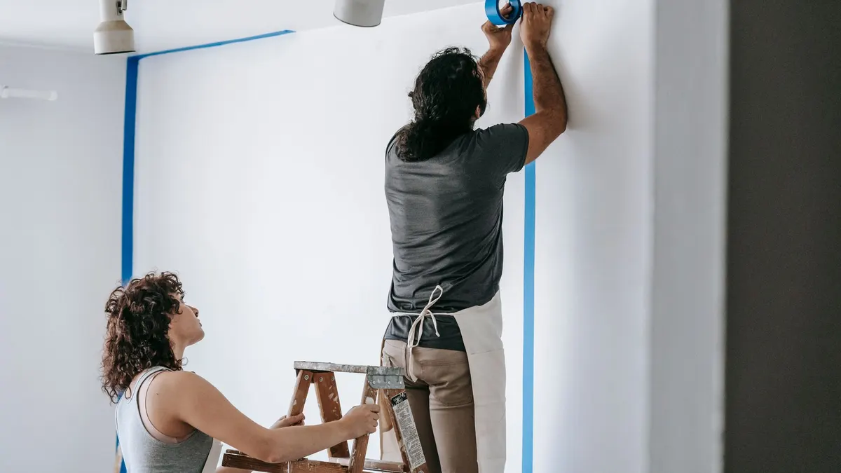 Painter working on an interior room during daylight hours