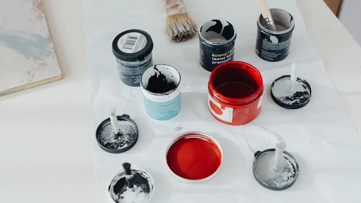 Paint cans and brushes arranged in a workshop