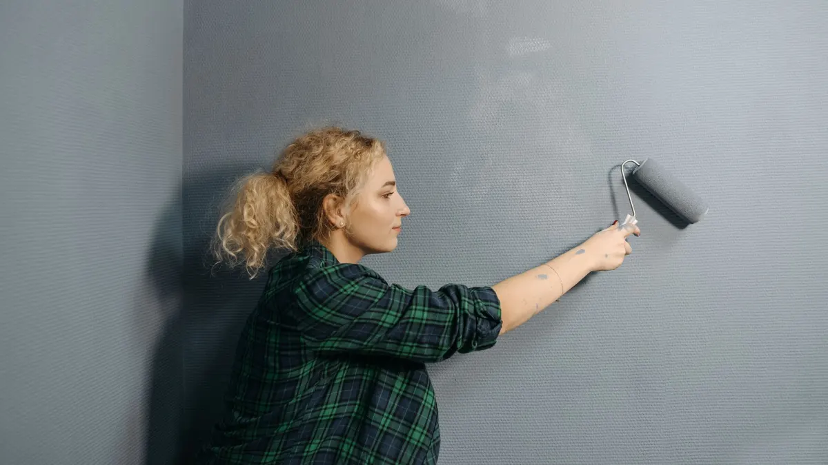 Painter applying a second coat of paint to a wall