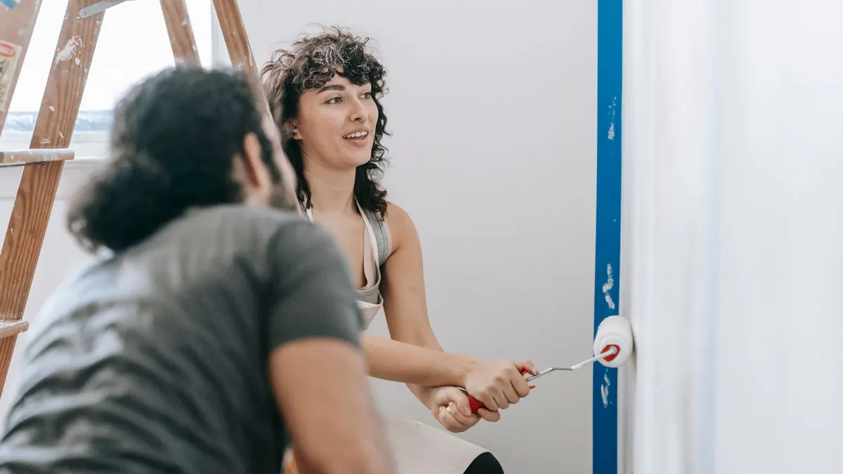Couple painting a bedroom wall together over a weekend project