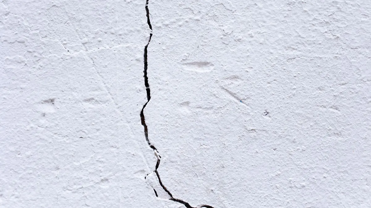 Stucco wall exterior with a visible hairline crack