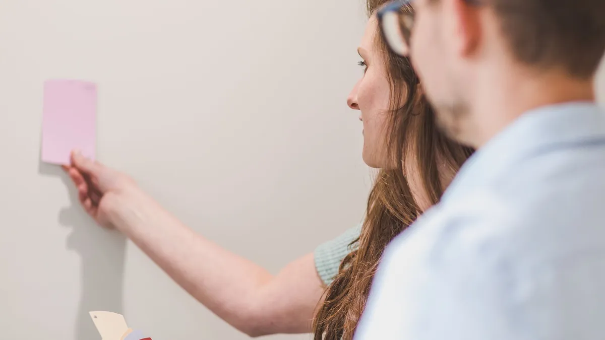 Homeowners comparing paint color and sheen swatches for their home