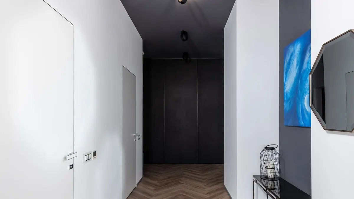 Wall being repainted white over a previously dark-colored surface